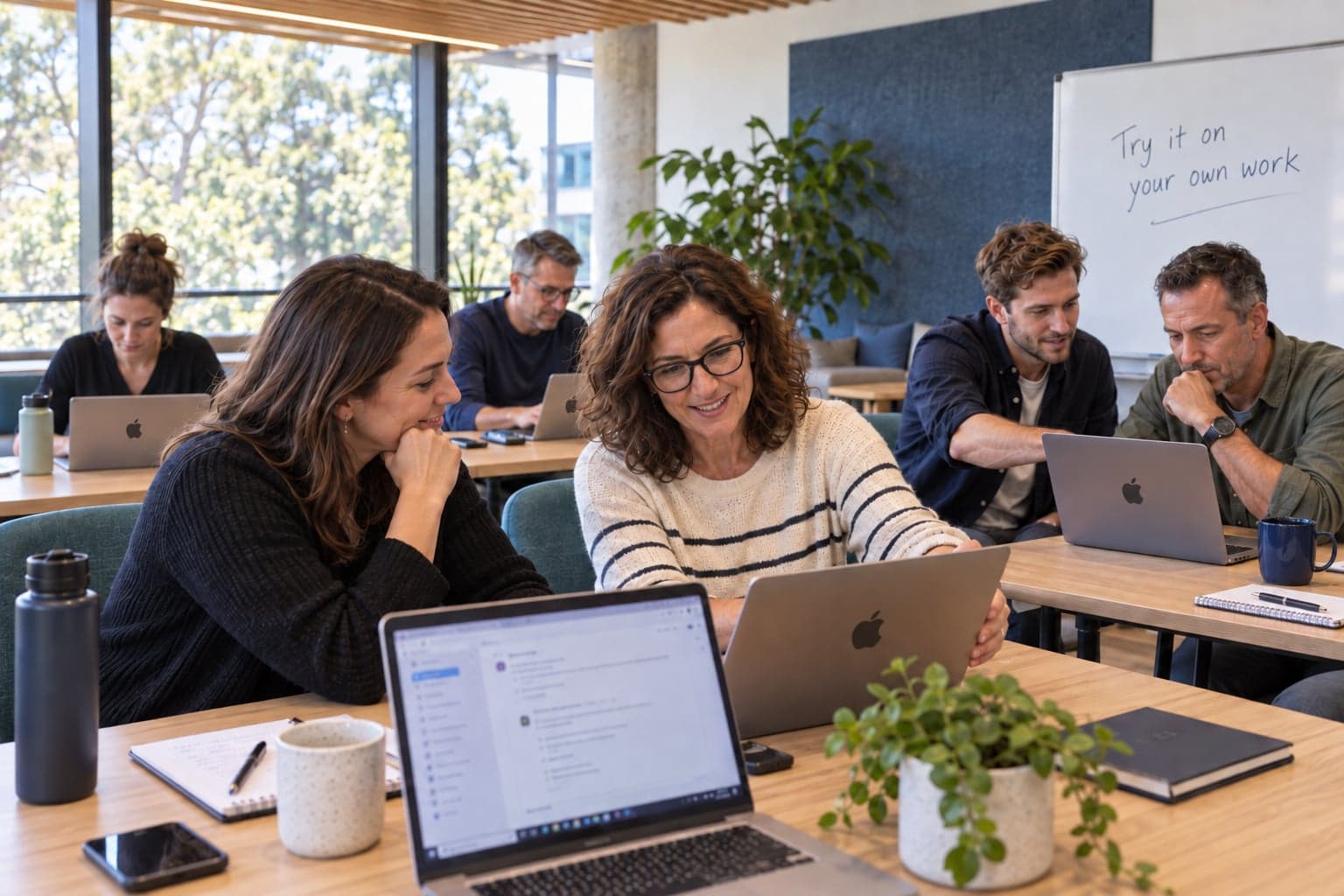 Illustrative hands-on AI training session with colleagues practising together on laptops